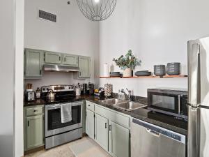 克利夫兰Downtown Condo的厨房配有绿色橱柜和不锈钢用具