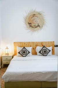 塔姆拉赫特乌兹达尔MojaSurf - Surf & Triathlon Camp的卧室配有白色的床和枕头。
