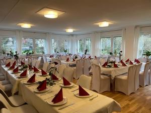 Waldrach西蒙兰德盖斯涛夫酒店的宴会厅配有桌椅和红色餐巾
