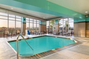 布卢明顿Spring Hill Suites Minneapolis-St. Paul Airport/Mall Of America的酒店大堂的游泳池,配有桌椅