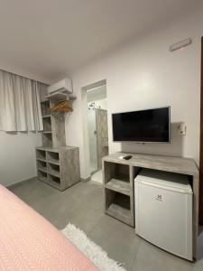 莫罗圣保罗Pousada Renda do Mar的一间卧室配有电视和一张书桌及电视