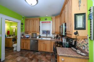 亚克朗Berrodin Bed & Breakfast的厨房设有木制橱柜和绿色的墙壁