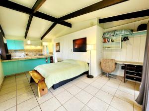 希洛阿诺特远足探险旅舍的一间带大床的卧室和一间厨房