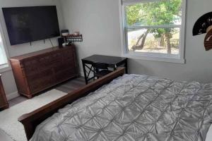 奥兰多House close Baldwin-park Lake & Downtown Orlando的一间卧室配有一张床和一台平面电视