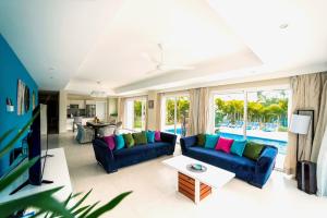 蓬塔卡纳Special offer! Villa Bueno with private pool&beach的客厅配有蓝色的沙发和电视