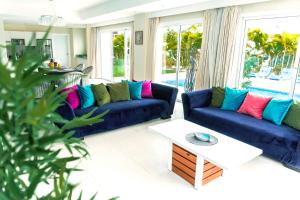 蓬塔卡纳Special offer! Villa Bueno with private pool&beach的客厅配有2张蓝色的沙发和1张桌子