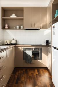 墨尔本MAC South Yarra by Melbourne Apartment Collection的厨房配有不锈钢用具,铺有木地板
