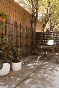 墨尔本MAC South Yarra by Melbourne Apartment Collection的木凳,坐在围栏旁,栽有盆栽植物