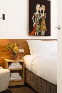 墨尔本MAC South Yarra by Melbourne Apartment Collection的一间卧室配有一张床,一张2位女性的照片