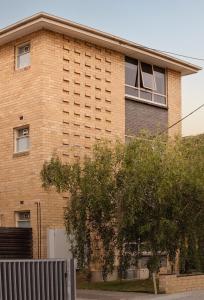 墨尔本MAC South Yarra by Melbourne Apartment Collection的前面有树的砖砌建筑