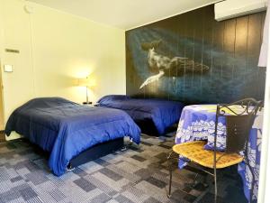 希洛阿诺特远足探险旅舍的一间卧室配有两张床,还有一幅鹿画