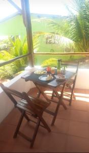 MaxaranguapeCasa paju的阳台上配有一张带食物的桌子和两把椅子