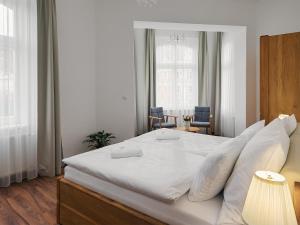 卡罗维发利IMPERIAL Apartments的卧室配有白色大床和白色枕头