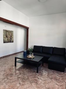 洛斯·亚诺斯·德·阿里丹Avenida 52 A的客厅配有黑色沙发和咖啡桌
