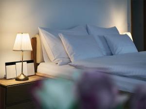卡罗维发利IMPERIAL Apartments的一张带蓝色枕头的床和一张桌子上的台灯