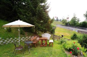 奥蒂塞伊嘉尼帕罗拉米克酒店的花园内桌椅和遮阳伞