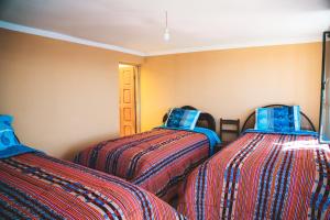 科帕卡巴纳Ima Sumaj Hostel的两张睡床彼此相邻,位于一个房间里