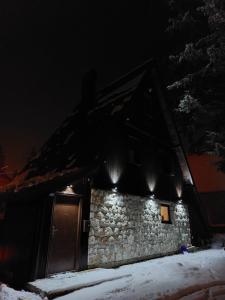 亚霍里纳Kuća Milica的一座石头建筑,上面有灯光,在雪中