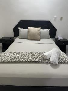 巴拿马城HOTEL BLUE COSTA Panama的一张带黑白棉被和枕头的床