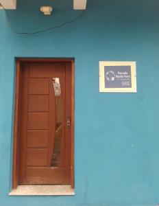 阿帕雷西达Pousada Mundo Novo的蓝色的建筑,带有木门和标志