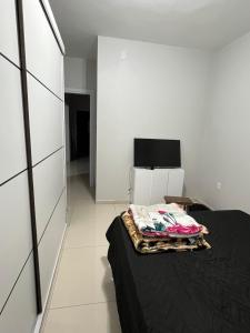 因贝Casa com piscina em Imbé/Rs的一间卧室配有一张床和一台电视。