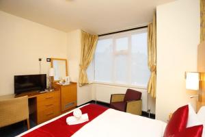 霍利Acorn Lodge Hotel Gatwick & Parking的酒店客房,配有床和电视