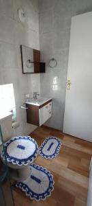 卡波布里奥kitinet Cabo Frio的浴室铺有2条蓝色和白色地毯。