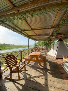 ChepoBayano Ecolodge的木甲板上设有野餐桌和帐篷