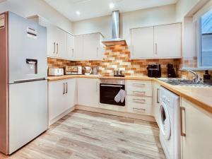 滨海纽比金Rothsay Beach House的厨房配有白色橱柜和洗碗机。