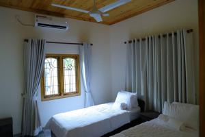 贾夫纳Lone Star Residence的一间卧室设有两张床和窗户。