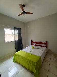 大伊瓜巴Casa em iguaba grande的一间卧室配有一张带吊扇的床