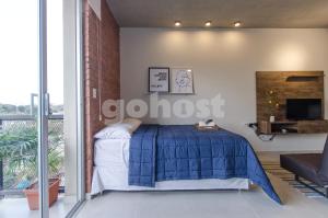 亚松森Comfy Loft Bbq Terrace And Balcony的一间卧室配有一张带蓝色棉被的床
