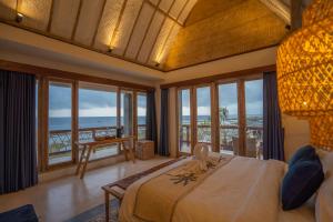 BatununggulALANA PENIDA HOTEL的一间卧室设有一张床,享有海景