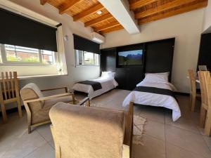 门多萨Ayres home的一间卧室配有两张床、一张沙发和椅子