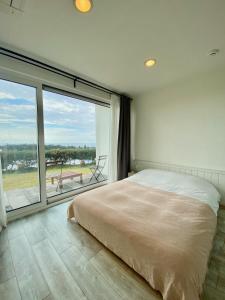 西归浦市拉波斯酒店的一间卧室设有一张大床和一个大窗户
