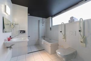 阿尔梅勒Leonardo Hotel Almere City Center的白色的浴室设有水槽和卫生间。