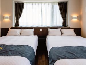 北谷町Private Condo Chatan Jagaru by Coldio Premium的带窗户的客房内的两张床