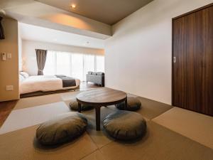 北谷町Private Condo Chatan Jagaru by Coldio Premium的一间卧室配有一张床、一张桌子和凳子