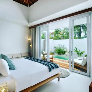 龙目岛库塔Neptune Studios Lombok的一间带大床的卧室和一个阳台