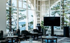 特里格尔Crowne Plaza Terrigal Pacific, an IHG Hotel的客房设有桌椅和大窗户。