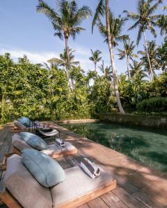 乌布Villa Bedulu Cliff Estate Ubud - Wood Side的一个带游泳池和棕榈树的度假村