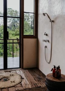 乌布Villa Bedulu Cliff Estate Ubud - Wood Side的带窗户的客房内带淋浴的浴室