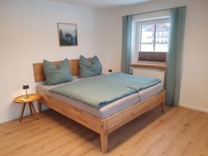 比绍夫斯维森Ferienwohnungen Winkler的一间卧室配有一张带蓝色枕头的床和一扇窗户。