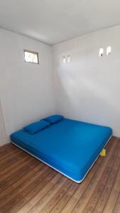 LemongaSollo Sollo Homestay的铺有木地板的客房内一张大型蓝色床