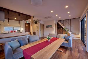 富士河口湖富士ガーデンビュー　空と庭と的客厅配有桌子和蓝色椅子