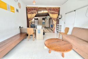 DukuHandira Homestay Syariah Padang RedPartner的客房设有长椅、桌子和书桌。