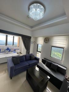 大雅台Splendido Tower 2 Ann's Unit的客厅配有蓝色的沙发和吊灯。