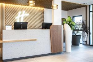 第戎Holiday Inn Dijon Sud - Longvic, an IHG Hotel的大堂的前台,墙上有十字架