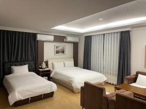 保宁市Hotel Terramar的酒店客房设有两张床和一张桌子。