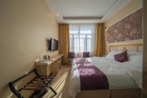 哈尔滨新启航宾馆哈尔滨太平机场店的一间酒店客房,配有一张床和一台电视